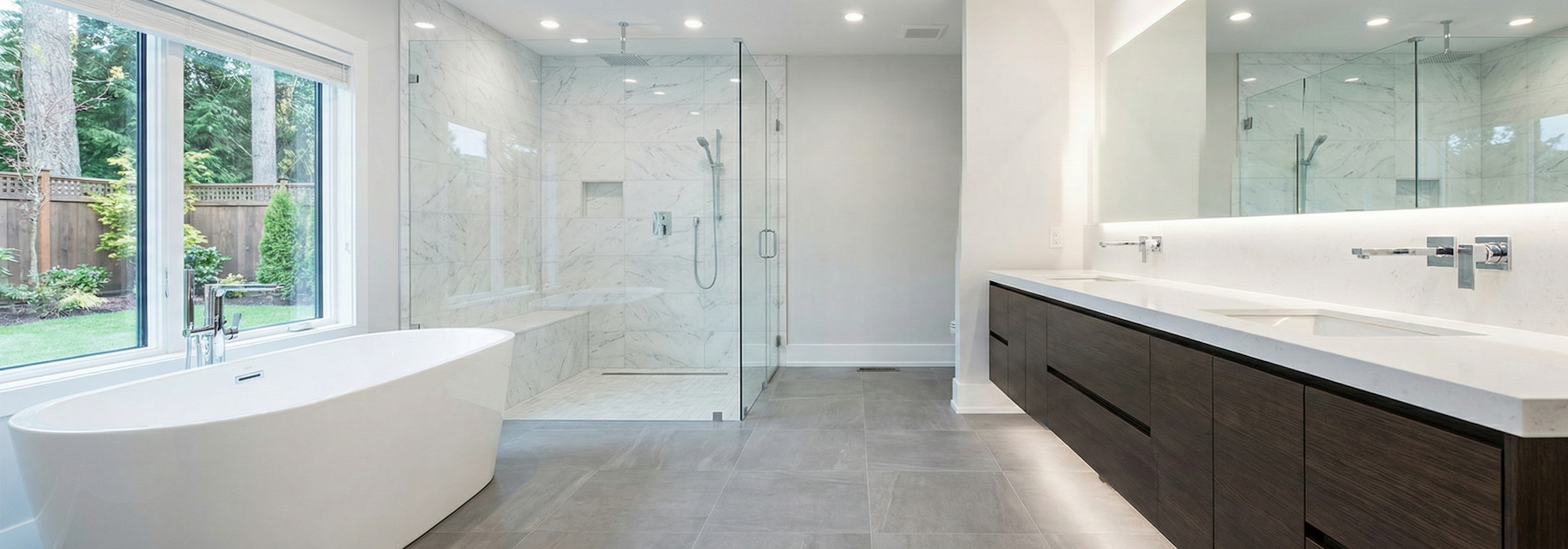 Expansive view of a finished spa-inspired master bathroom remodel, showing a freestanding soaking tub, a large glass walk-in marble shower, and a modern double vanity.